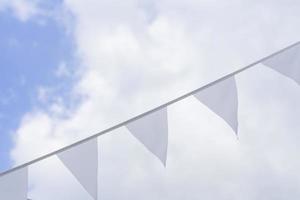 White triangle garland against blue sky. Celebration outdoors decoration. Festive concept photo