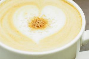 close up of big cup of freshly brewed cappuccino with soft foam and brown sugar and drawing heart by barista photo