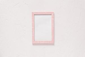 wooden photo frame on white wall baxkground. Minimal flat lay with copy space. Toned