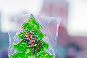 Sweet candy on a stick in shape of christmas tree. Christmas treats- colorful lollipops in the form of spruce photo