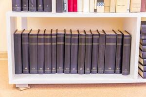 old books on a white shelf in the library photo