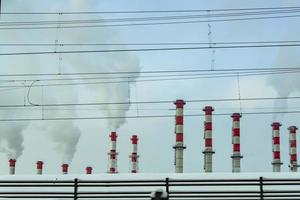 Smoke from old red and white smoke stacks. photo