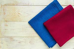 Top view of cloth napkins of blue and burgundy colors on rustic white background. Copy space for text photo