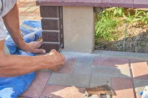 A worker installs panels brown siding on the facade of the house photo