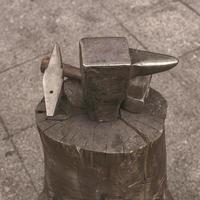 A hammer near anvil. Tool using in a blacksmith shop photo