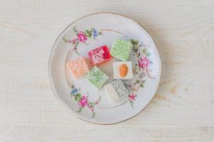 Traditional turkish delight on a plate. Assorted Oriental sweets. Top view. photo