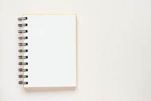 Clean spiral note book for notes and messages on rlight beige background. Minimal business flat lay photo