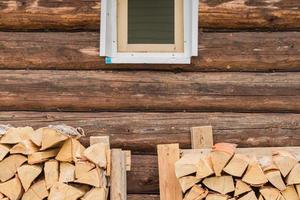 two stacks of firewoods near log wall under the window. outdoor storage of woodpile photo