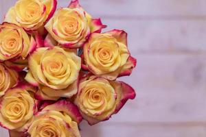 top view of bunch of roses of yellow and red colors with water drops. greeting card concept with copy space photo