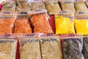 Assorted herbs and spices in clear plastic bags on the market photo