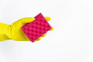 hand with yellow glove holding red sponge for cleaning on white background photo