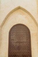 fragment of oriental door on white wall photo