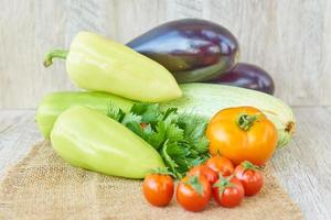 close up of freshly pickled harvest of vegetbles - bell pepper, drill and tomatoes on wooden table. Rustic style. Organic healthy food concept with copy space photo