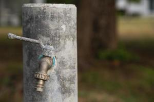 An old water tap with rusty handle photo