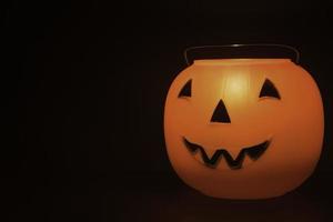 Halloween pumpkin basket on the black background photo