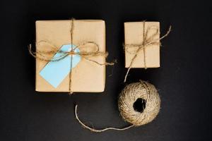 cajas de regalo hechas a mano envueltas en papel artesanal con etiqueta de tarjeta de papel azul y cuerda para decoración. foto