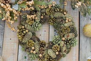 Close up of Christmas wreath made of cones covered with snow and glitter. New year interior decoration photo