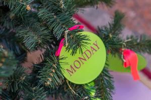 fondo de vacaciones de navidad y año nuevo. árbol de navidad decorado con bola roja y letras de lunes. concepto de celebración foto