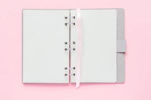 Top view of open empty notebook with cover from recycled paper on pastel pink colorful background photo