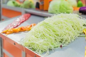 Fresh green shredded cabbage on the table. Vegetable shredder presentation photo