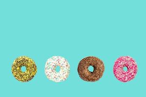 multicolored frosted donuts with colorful sprinkles  and hazels on blue background. photo