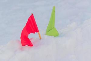 banderas verdes y rojas en la nieve. puesto de control de competiciones de deportes de invierno. foto