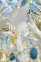 colorfull easter egg tree. brights eggs and tender feathers hanging from branches. photo