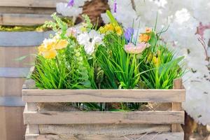 decoración colorida con flores artificiales al aire libre - flores florecientes en caja de madera foto