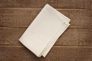 top view of cloth napkins of beige, color on rustic brown wooden table. photo