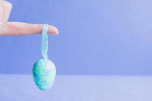 Female hand holding blue sparkling easter egg. photo