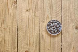 blue berry in a bowl on wooden table with copy space photo