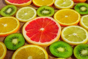 frame with slices of oranges, lemons, kiwi, grapefruit pattern on wooden background. Copy space photo