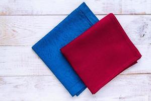 Top view of cloth napkins of blue and burgundy colors on rustic white background. Copy space for text photo