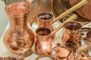 Vintage copper kitchenware - turkish coffee pots and jars displayed in flea market photo