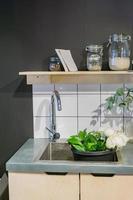 wash metal sink and various glass jars on metal table next to basket with flowers. Flowershop arrangement photo