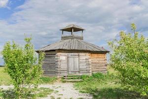 wooden house at the edge of the forest under dramatic sky photo