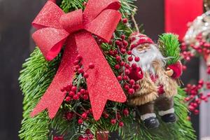 Christmas and New Year holidays background.  Christmas tree decorated with red berries, bow and santa.  Celebration concept photo