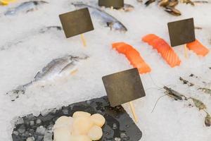 Fresh seafood - Salmon, shrimp, fish and scallops - displayed on ice grocery store. Selective focus. photo