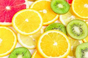 citrus slices - kiwi, oranges and grapefruits on white background. Fruits backdrop photo