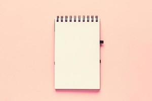 Top view of open empty notebook with cover from recycled paper on pastel pink colorful background photo