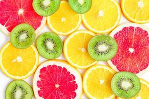 close up of citrus slice, kiwi, oranges and grapefruits isolated on white background. Fruits backdrop photo