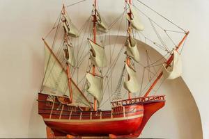 Model of an old sailing ship on white wall background. photo