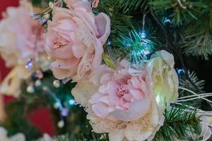 primer plano del árbol de navidad decorado con flor rosa tierna. foto