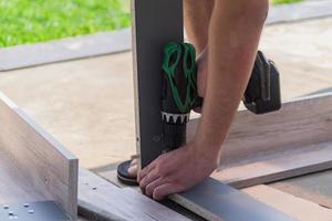 furniture assembling - Carpentry screws for a knock down wooden table. photo