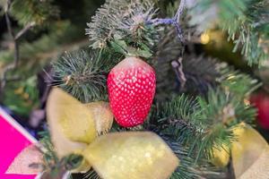 Christmas and New Year holidays background.  Christmas tree decorated with strawberry, selective focus. Celebration concept photo