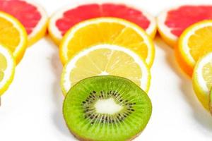 close up of citrus slice, kiwi, oranges and grapefruits isolated on white background. Fruits backdrop photo