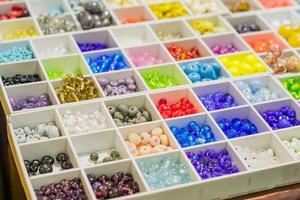 colorida mezcla de perlas de vidrio murano. variedad de formas y colores para hacer collares o pulseras. materiales de bricolaje foto