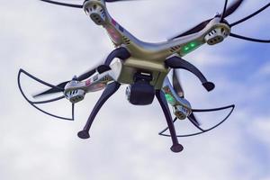 flying drone with remote control against blue sky background. photo