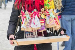 Small Shrovetide dolls on street fair - scarecrow for burning as symbol of spring coming. photo