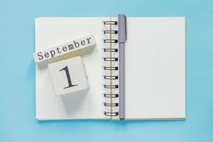 September 1 on a wooden calendar on study textbook on  blue background. Back to school concept photo